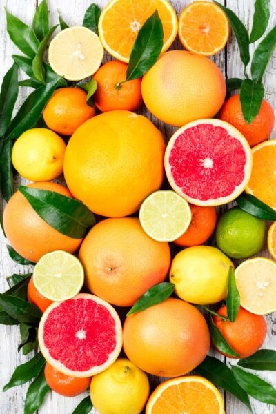 Citrusfruitsbackground.Assortedfreshcitrusfruitswithleaves.Orangegrapefruitlemonlimetangerine_edited